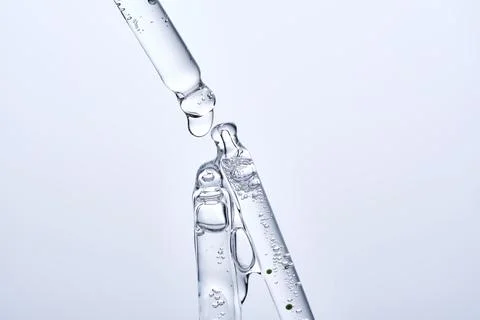 Three different face serum pipettes on a neutral background. Stock Photos