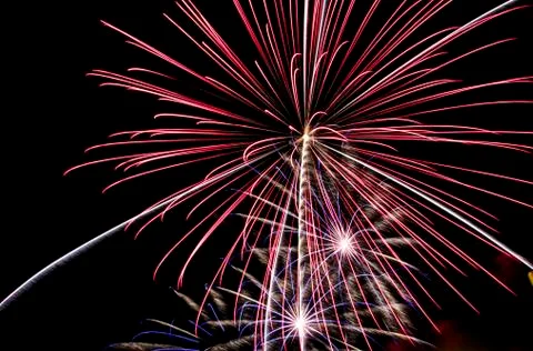 Three different fireworks explode Stock Photos