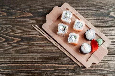 Three different kinds of Japanese rolls with wasabi and ginger on bamboo tray Stock Photos