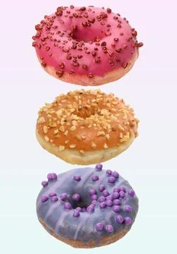 Three different levitating donuts with colored glaze, nut and berry sprinkles Stock Photos