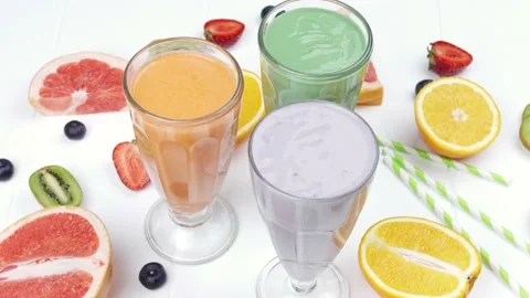 Three different milkshakes with fruits on a rustic white wooden background. Flat Stock Footage 156078329