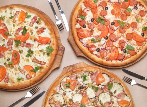 Three different pizzas are on the table Stock Photos