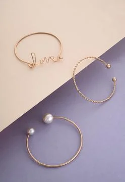 Three different shape modern bracelets on pastel colors paper background Stock Photos