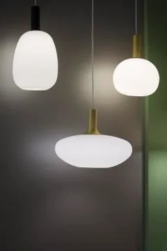 Three different-shaped chandeliers, matte white pendant lights. Design minima Stock Photos