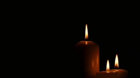 Three different sizes white candles burning in front of black background. Stock Footage 43721099