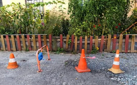 Three different traffic cones are blocking path to someone's garden with fence 스톡 사진