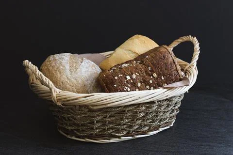 Three different types of bread in a wicker basket. Stock Photos