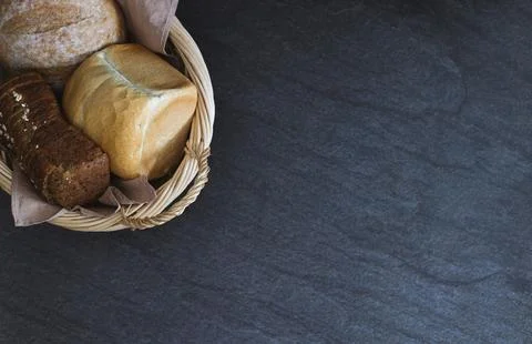 Three different types of bread in a wicker basket. Stock Photos