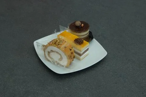 Three different types of desserts are displayed on a white plate Stock Photos