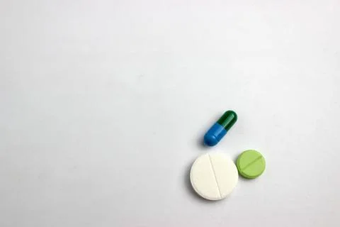 Three different types of pills are arranged against a white background. Stock Photos
