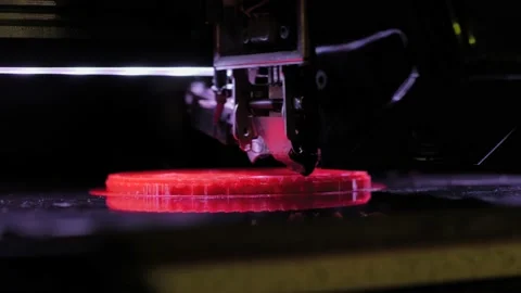 Three dimensional printing machine making red flat physical 3D model - close up Stock Footage 156381633