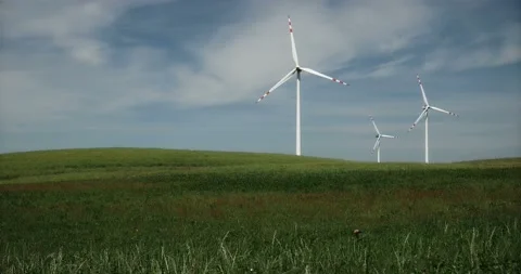 Three distant wind turbines on the big farm field 動画素材 90870665