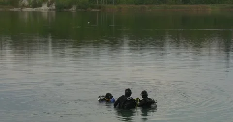 Three Divers Distantly Are Standing in The Water Checking their Equipment Going Stock Footage 55102157