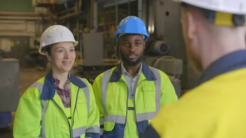 Three diverse technicians in safety gear gesturing high-five and smiling Stock Footage 131315220