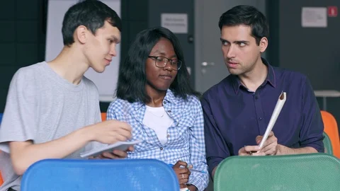 Three diverse university students comparing notes Stock Footage 105190957