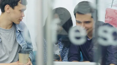 Three diverse young people looking at laptop screen Video stock 105189828