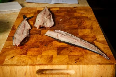 Three divided part of raw mackerel fillet with bones lie on wooden tray on ki Stock Photos