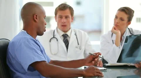 Three doctors talk to a nurse Stock Footage 10860597