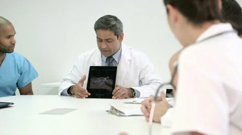 Three doctors using digital tablet in a meeting. Stock Footage 36080376