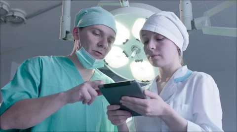 Three doctors using a tablet in a bright office Stock Footage 59058349