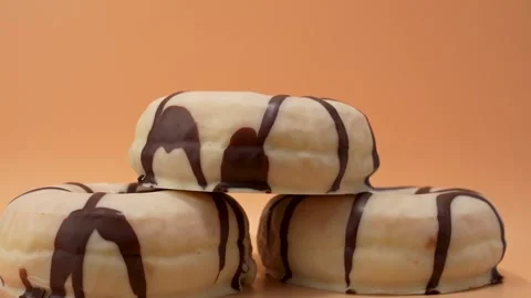 Three donuts stacked on top of each other with chocolate drizzle Stock Footage 279340400
