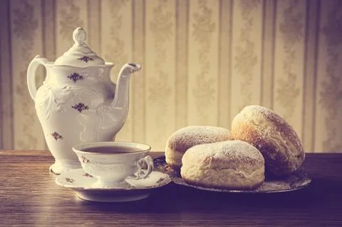 Three donuts on tray with cup of coffee with old-fashioned wallpaper during c Stock Photos
