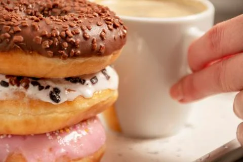 Three donuts on a white tray with a cup of coffee Foto stock