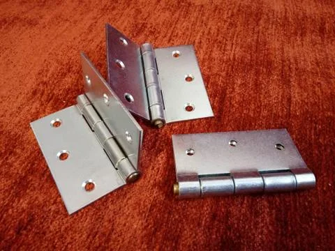 Three door hinges on red background Stock Photos