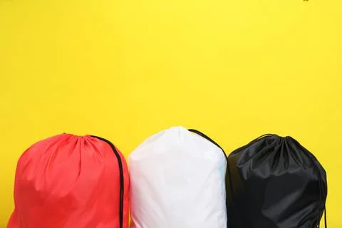 Three drawstring bags on yellow background. Space for text Foto stock