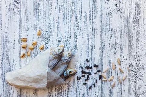 Three dried fish bream lie on a bright wooden table in the lower left corner Stock Photos