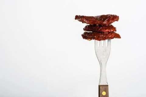 Three dried tomatoes on fork Stock Photos