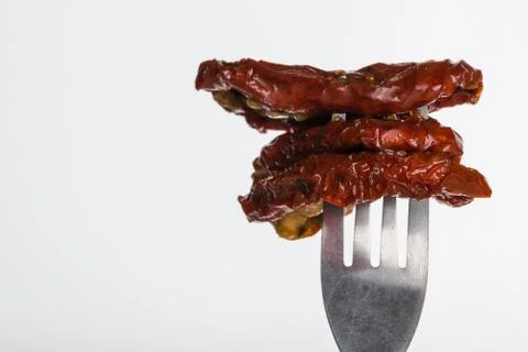 Three dried tomatoes impaled on fork Stock Photos