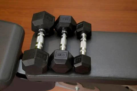 Three dumbbells on a bench Stock Photos