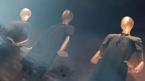 Three dummies on a storefront with a reflection of the evening sky. Double ex Stock Photos