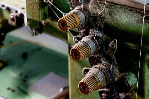 Three dusty spools of thread attached to an old industrial machine Stock Photos