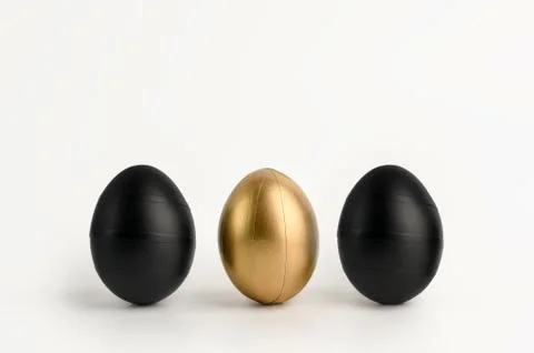 Three Easter black golden decorated eggs on white background. Stock Photos