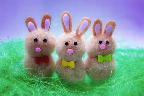 Three Easter bunnies in a green plastic grass Stock Photos