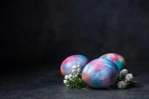 Three Easter colored eggs with spring flowers Stock Photos