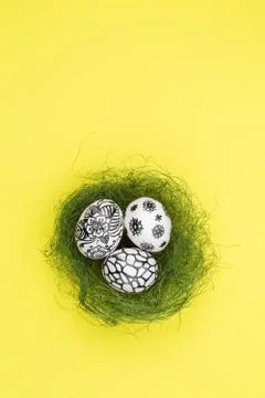 Three easter eggs are painted in black and white lie in a green nest. Foto stock