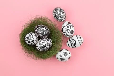 Three easter eggs are painted in black and white lie in a green nest. Foto stock