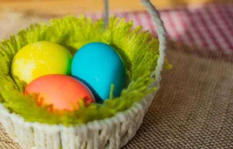 Three Easter eggs in a basket. Stock Photos