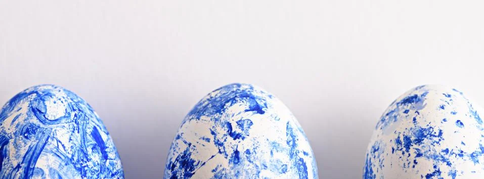 Three Easter eggs in the color of the year-classic blue with gradient effect  Stock Photos