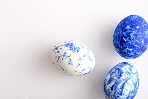 Three Easter eggs in the color of the year-classic blue with a gradient effec Stock Photos