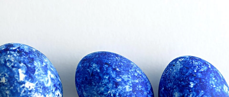 Three Easter eggs in the color of the year-classic blue with gradient effect Stock Photos