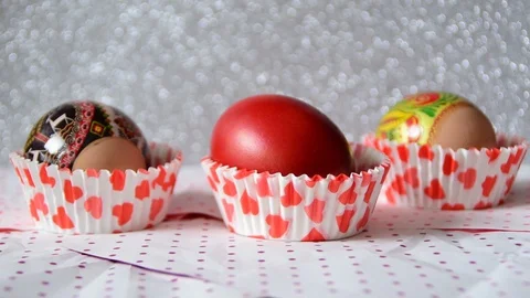 Three Easter eggs in cups of red heart Video stock 87144349