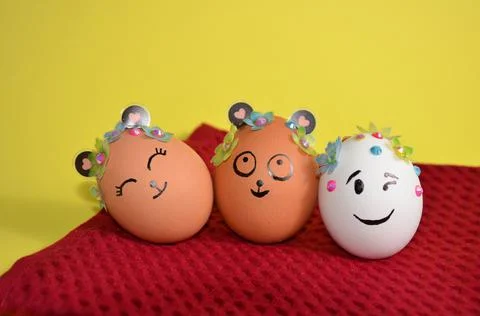 Three Easter eggs with cute faces on a red napkin. Spring. Easter. Foto stock