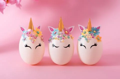 Three Easter eggs in the form of a unicorn with golden corn and flowers on a Stock Photos