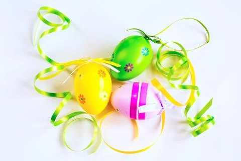 Three Easter eggs, green and yellow ribbons Stock Photos
