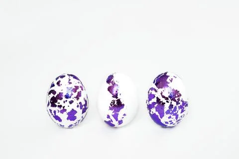Three Easter eggs with pieces of decorated foil in a row on a white backgroun Stock Photos