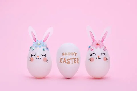 Three Easter eggs in a row on a pink background with copy space. Stock Photos